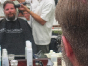 Getting hair and beard chopped off, amused onlookers